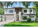 Stunning two-story home with a modern design, manicured lawn, and a brick-paved driveway leading to an attached garage at 1620 S Eola Dr, Orlando, FL 32806