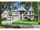 Beautiful home with a lush green lawn, brick driveway, and attached garage in a serene, tree-lined neighborhood at 1620 S Eola Dr, Orlando, FL 32806