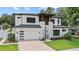 Charming two-story house with a modern facade, featuring a well-kept lawn and brick driveway leading to the garage at 1620 S Eola Dr, Orlando, FL 32806