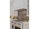 White kitchen hood and backsplash over stainless steel range and oven with bronze accents at 1620 S Eola Dr, Orlando, FL 32806