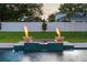 Backyard pool and spa featuring tiered tilework, elegant fire bowls, and an immaculate lawn at 1620 S Eola Dr, Orlando, FL 32806