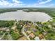 Aerial view of a neighborhood with lush landscaping, a serene lake, and luxurious homes at 223 Royal Oaks Cir, Longwood, FL 32779
