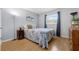 Well-lit bedroom featuring light hardwood floors, light blue walls, and an inviting window view at 223 Royal Oaks Cir, Longwood, FL 32779