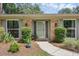 Inviting entryway featuring a glass door, green trim and lush landscaping at 223 Royal Oaks Cir, Longwood, FL 32779