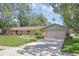 Charming one-story brick home with well-manicured lawn, mature trees, and a two-car garage at 223 Royal Oaks Cir, Longwood, FL 32779