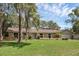 Landscaped front yard featuring a brick home with lush lawn and inviting walkway at 223 Royal Oaks Cir, Longwood, FL 32779