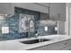 Kitchen with stainless steel sink, blue tile backsplash, and white quartz countertops at 223 Royal Oaks Cir, Longwood, FL 32779