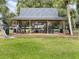 A covered picnic pavilion surrounded by trees and a large green space provides a shaded community gathering spot at 223 Royal Oaks Cir, Longwood, FL 32779