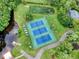 Aerial view of community tennis courts and a pond surrounded by mature trees at 223 Royal Oaks Cir, Longwood, FL 32779