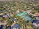 Aerial shot showcasing community tennis courts amidst a lush, green neighborhood at 223 Royal Oaks Cir, Longwood, FL 32779