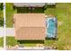 Aerial view of the property showcasing the house, roof, screened-in pool, and the surrounding yard at 233 Cadiz Loop, Davenport, FL 33837
