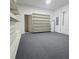 Unfinished basement area featuring shelving, water heater, and gray carpet at 233 Cadiz Loop, Davenport, FL 33837
