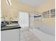 Bright bathroom with a dual sink vanity, soaking tub, and separate glass-enclosed shower at 233 Cadiz Loop, Davenport, FL 33837