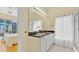 Bright bathroom featuring double sinks, modern fixtures, and a view into the screened-in patio area at 233 Cadiz Loop, Davenport, FL 33837