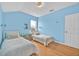 Bright bedroom with twin beds, blue walls and blonde wood floors, offering cozy charm at 233 Cadiz Loop, Davenport, FL 33837