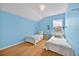 Bright bedroom with twin beds, blue walls and blonde wood floors, offering cozy charm at 233 Cadiz Loop, Davenport, FL 33837