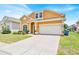 Well-maintained home with a brick driveway, two-car garage, and tidy landscaping at 233 Cadiz Loop, Davenport, FL 33837