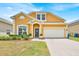 Charming two-story home featuring a well-manicured lawn, brick driveway, and attached two-car garage at 233 Cadiz Loop, Davenport, FL 33837