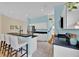Well-lit kitchen with a breakfast bar, stainless steel refrigerator, and white cabinets at 233 Cadiz Loop, Davenport, FL 33837