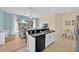 Modern kitchen with an island and bar, featuring black countertops and an open-concept view of the living area at 233 Cadiz Loop, Davenport, FL 33837