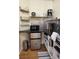 Compact kitchen area featuring stainless steel appliances, dark countertops, and light wood laminate flooring at 233 Cadiz Loop, Davenport, FL 33837
