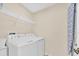 Practical laundry room equipped with a washer, dryer, and shelving for storage at 233 Cadiz Loop, Davenport, FL 33837
