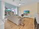Cozy living room featuring hardwood floors, a ceiling fan, and an open view of the screened-in lanai at 233 Cadiz Loop, Davenport, FL 33837