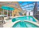 A large, enclosed pool area with a hot tub and a seating area at 233 Cadiz Loop, Davenport, FL 33837