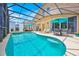 A large, enclosed pool area with a hot tub and a seating area at 233 Cadiz Loop, Davenport, FL 33837