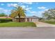 Home exterior with a two-car garage, adjacent yard with palm trees, and concrete driveway at 247 Carmen Ln, Debary, FL 32713