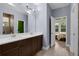 Bright bathroom featuring a double vanity, wood-look flooring, and an open view to bedroom at 2829 Red Alder Blvd, Ocoee, FL 34761