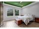 Relaxing bedroom with natural light, wood tile flooring, and a decorative ceiling at 2829 Red Alder Blvd, Ocoee, FL 34761