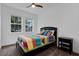 Cozy bedroom with a vibrant quilt, two large windows, and a classic ceiling fan at 2829 Red Alder Blvd, Ocoee, FL 34761