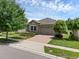 Charming home exterior with stone accents, paver driveway, and well-manicured landscaping at 2829 Red Alder Blvd, Ocoee, FL 34761