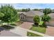 Well-maintained home featuring a stone facade, brick driveway, manicured lawn, and an attached two-car garage at 2829 Red Alder Blvd, Ocoee, FL 34761