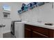 Efficient laundry room includes washer, dryer, utility sink, and shelving for storage at 2829 Red Alder Blvd, Ocoee, FL 34761