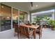 Cozy covered patio with a wooden table, seating, potted plants, and views into the home at 2829 Red Alder Blvd, Ocoee, FL 34761