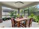 Inviting screened patio features a dining table, ceiling fan, and lush plants at 2829 Red Alder Blvd, Ocoee, FL 34761