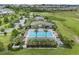 Aerial view of a pristine community pool, complete with lounge chairs and manicured greenery at 2829 Red Alder Blvd, Ocoee, FL 34761