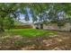 Spacious backyard with lush green lawn, mature trees, and a privacy fence, perfect for outdoor activities and relaxation at 2843 Grove Dr, Sanford, FL 32773