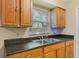 Kitchen features wooden cabinets, black countertops, and a double stainless steel sink at 2843 Grove Dr, Sanford, FL 32773