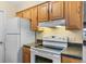 Well-lit kitchen with wooden cabinets, black countertops, and a full range of white appliances at 2843 Grove Dr, Sanford, FL 32773
