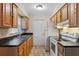 Functional kitchen featuring wooden cabinets, black countertops, and a full suite of appliances at 2843 Grove Dr, Sanford, FL 32773