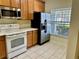 Functional kitchen with white appliances, wood cabinets and tiled floor at 3321 Wilshire Way Rd # 6, Orlando, FL 32829
