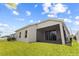 Exterior backyard view of home featuring a screened in patio, lush lawn and landscaped garden at 337 Meadow Pointe Dr, Haines City, FL 33844