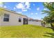 Exterior backyard view of home featuring a screened in patio, lush lawn and white vinyl fencing at 337 Meadow Pointe Dr, Haines City, FL 33844