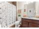 Well-lit bathroom with a granite vanity, decorative shower curtain, and neutral finishes at 337 Meadow Pointe Dr, Haines City, FL 33844