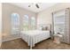 Serene bedroom featuring three arched windows, a comfortable bed, and neutral tones for a peaceful ambiance at 337 Meadow Pointe Dr, Haines City, FL 33844