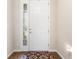 Bright entryway featuring a white door with decorative glass and a patterned rug on hardwood floors at 337 Meadow Pointe Dr, Haines City, FL 33844