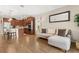 Bright living room featuring wood floors, a comfortable couch, and an open flow to the modern kitchen at 337 Meadow Pointe Dr, Haines City, FL 33844